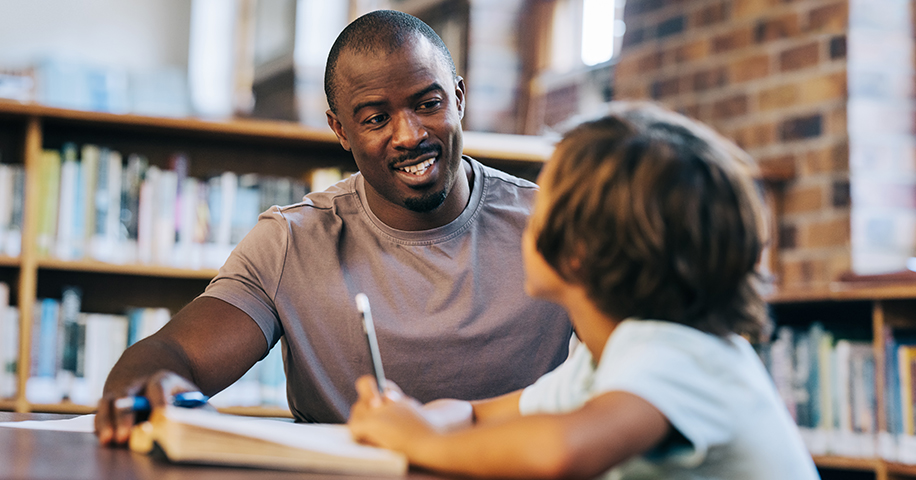 Educator working with child in a library
